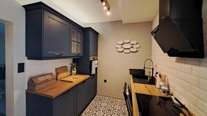 A compact kitchen with dark cabinets, a wooden countertop, and a tiled backsplash. - Villa Hidden Gem (Bribir)