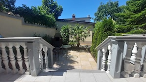 A courtyard with a tiled floor, a small round table, and a chair. There are two white balustrades on either side. - Villa Hidden Gem (Bribir)