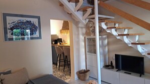 A modern living room with a staircase, a dining area, and a kitchen visible through an open door. - Villa Hidden Gem (Bribir)