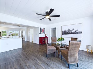 Relax in this open-plan living area with a kitchen, dining space, and ceiling fan.