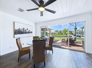 Relax in this serene room with a sliding glass door leading to a patio area overlooking the pool and surrounding landscape.