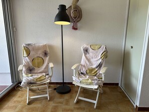 Two comfortable chairs with patterned upholstery sit in a room with a tiled floor and a door.