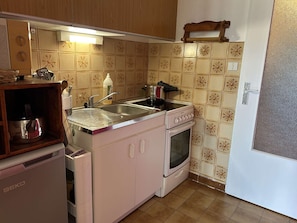 Enjoy cooking in this well-equipped kitchen with a refrigerator, sink, oven, and ample storage.
