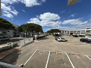 Park your car in the designated spaces surrounded by lush trees and a scenic view.