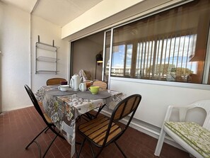 Enjoy meals for two in this cozy dining area with a table, chairs, and a view of the surrounding landscape.