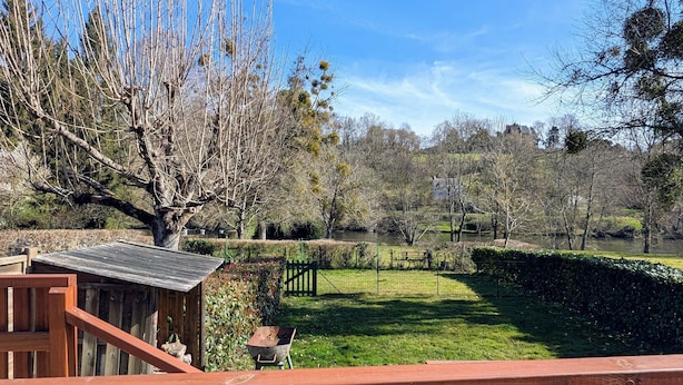 A wooden deck with a view of a well-maintained lawn and a pond. - Cottage by the Creuse River with Private Garden (Ceaulmont)