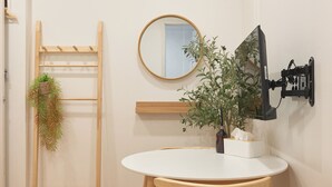A room with a wooden ladder, a round mirror, a wall-mounted TV, a white table, and a potted plant. - Dawoo House2 (Seoul)