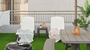 A patio with a barbecue grill, two white chairs, a table with a lamp, and an umbrella. - Dawoo House2 (Seoul)