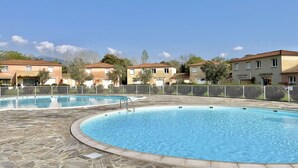 Ein Poolbereich mit mehreren Pools, umgeben von Mehrfamilienhäusern.