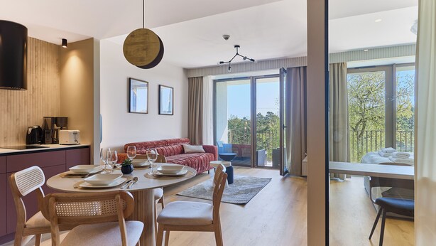 Una cucina moderna con zona pranzo, divano e vista sull'esterno.
