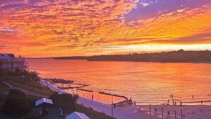 A waterfront view with a sunset, a pier, and a promenade. - Beachfront Luxury 3 Beds With Ocean View Balcony (Sydney)