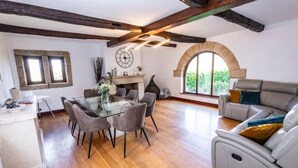 Una habitación amplia con una mesa de comedor, sillas, un sofá y una chimenea.