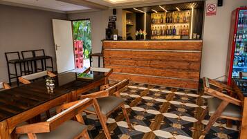 A bar area with a counter, bar stools, and a patterned floor.
