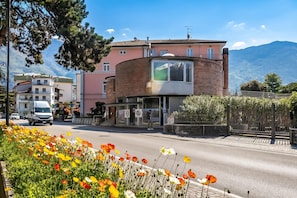 A building with a curved facade, a visible entrance, and a mountain backdrop. - The Arco Round House With Terrace & Parking (Arco)