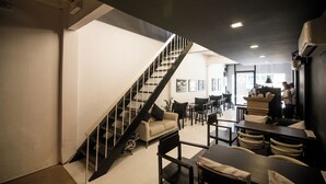 A modern interior with a staircase, seating area, and a counter. - Chatel Samyan BKK (Bangkok)