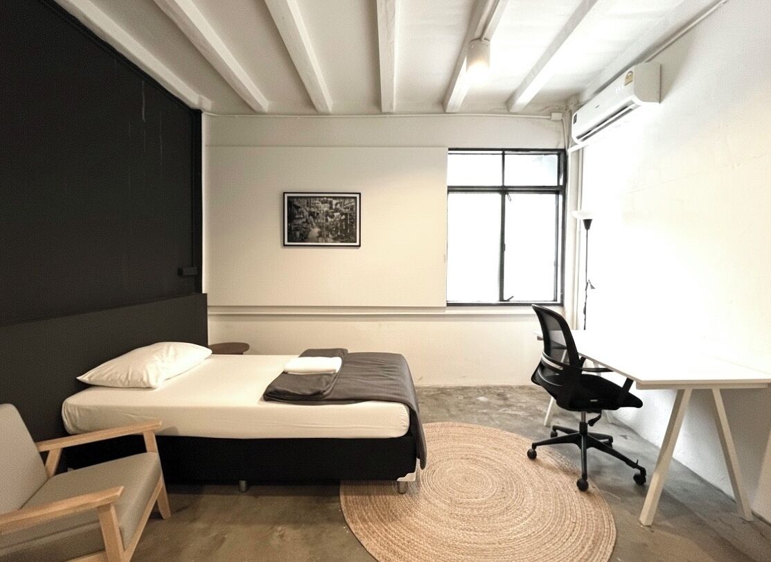 Ein modernes Schlafzimmer mit einem Bett, einem Schreibtisch und einem Stuhl.