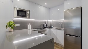 Een moderne keuken met roestvrijstalen apparatuur, een ingebouwde magnetron en een strak aanrecht.