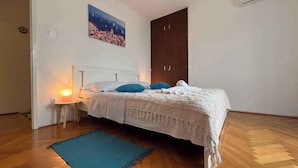 Une chambre à coucher comprenant un lit, une table de chevet, un tableau accroché au mur et une armoire.