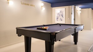 A pool table with balls in the center, a wall with 'LEISURE AREA' text, and a framed picture on the wall. - Lapa Diplomatic Flat 0 4 by Feel Lisboa (Lisbon)