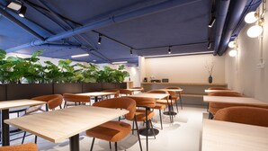 A modern interior with tables and chairs, a plant wall, and a counter. - Lapa Diplomatic Flat 0 4 by Feel Lisboa (Lisbon)