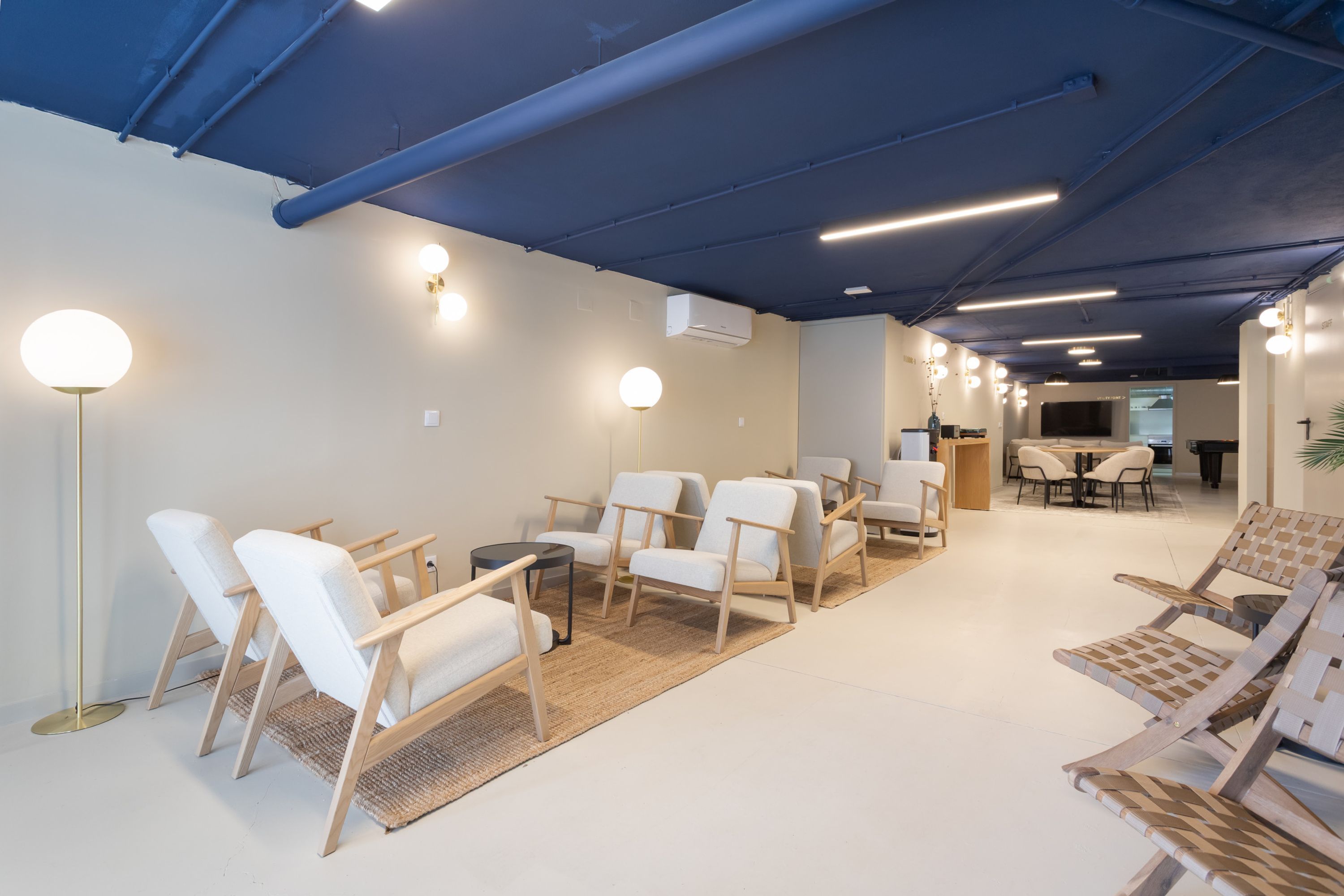 Un intérieur moderne avec des chaises blanches, une table basse et un coin repas.