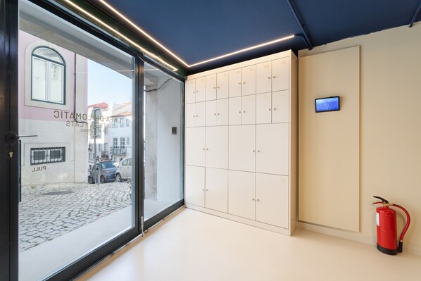 Un interior moderno con una puerta de vidrio que da al exterior, una fila de taquillas y un extintor.