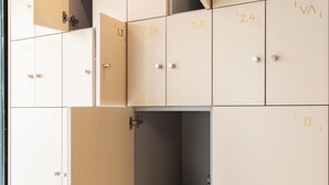 Eine Reihe von beigefarbenen Schließfächern mit den Nummern 0,4 bis 2,4, einige davon geöffnet, inklusive sichtbarer Türgriffe.