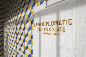 Una pared con un patrón geométrico y el texto que dice "LAPA DIPLOMATIC SUITES & FLATS by FEEL LISBOA".