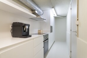 Une cuisine moderne équipée d’une machine à café, d’un four à micro-ondes et d’un four encastré.