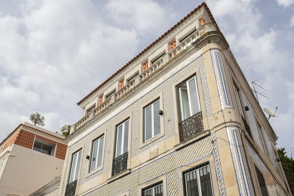 Un edificio con fachada de tejas, múltiples ventanas y balcones.