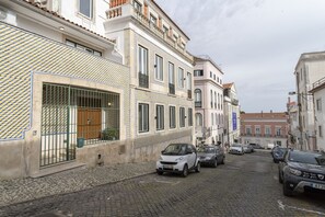A cobblestone street with parked cars and buildings with traditional architecture. - Lapa Diplomatic Flat 1 4 by Feel Lisboa (Lisbon)