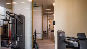 A modern gym with various exercise machines, a bench, and a mirrored wall. - Spacious Beachside 2BR M at Five Palm Jumeirah (Dubai)