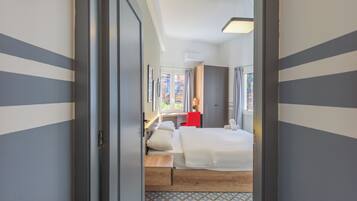 A hotel room with a bed, a desk, and a chair.
