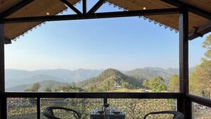 Un espacio de estar al aire libre cubierto con vistas a montañas.
