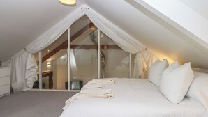 Une chambre à coucher avec un grand lit, un baldaquin et une vue sur la salle de bain.