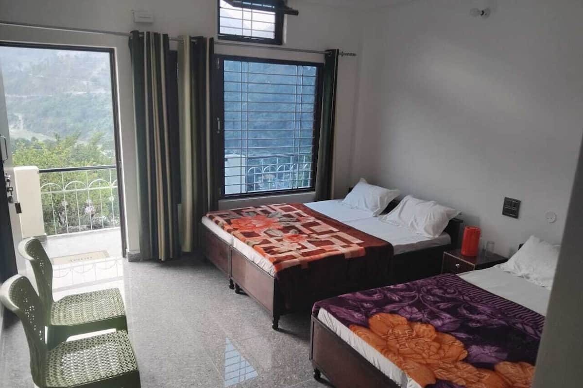 Ein Hotelzimmer mit zwei Betten, einem Sessel und einem Balkon mit Bergblick.