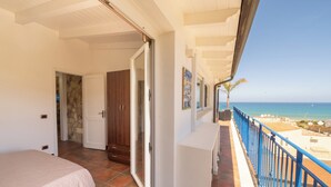 A bedroom with a bed, a bathroom, and a balcony with a view of the sea. - Apartment Breathtaking View 200 meters from the Sea! (Alcamo)