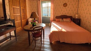 Una habitación con cama, escritorio, silla, lámpara y ventana.