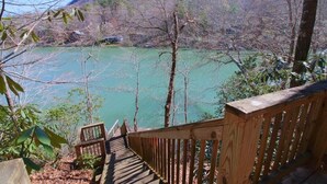 A wooden staircase leading to a viewpoint overlooking a body of water surrounded by trees. - Bald Mountain Lake Retreat (Lake Lure)