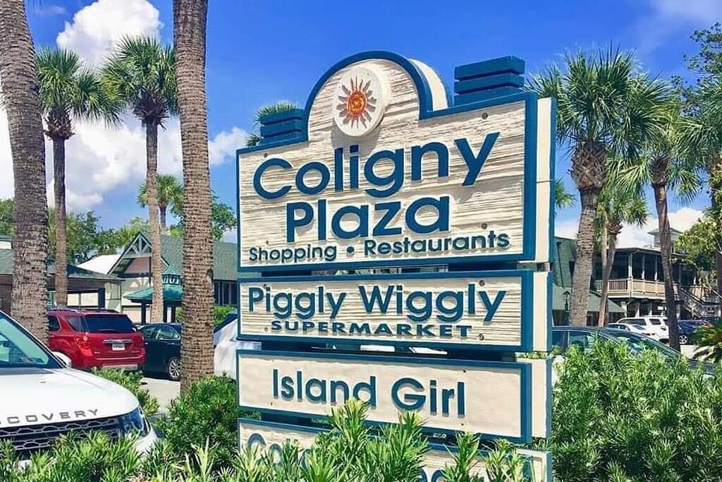 A sign for Coligny Plaza with shopping and restaurants, including Piggly Wiggly supermarket and Island Girl.