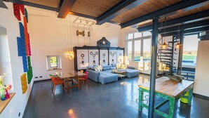 A spacious living area with a blue sofa, wooden table, and colorful wall decorations. - E-Loft Altes Wasserwerk Tecklenburg (Tecklenburg)
