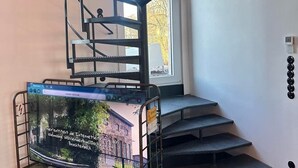 A spiral staircase with metal railings and a cart with a map. - E-Loft Altes Wasserwerk Tecklenburg (Tecklenburg)