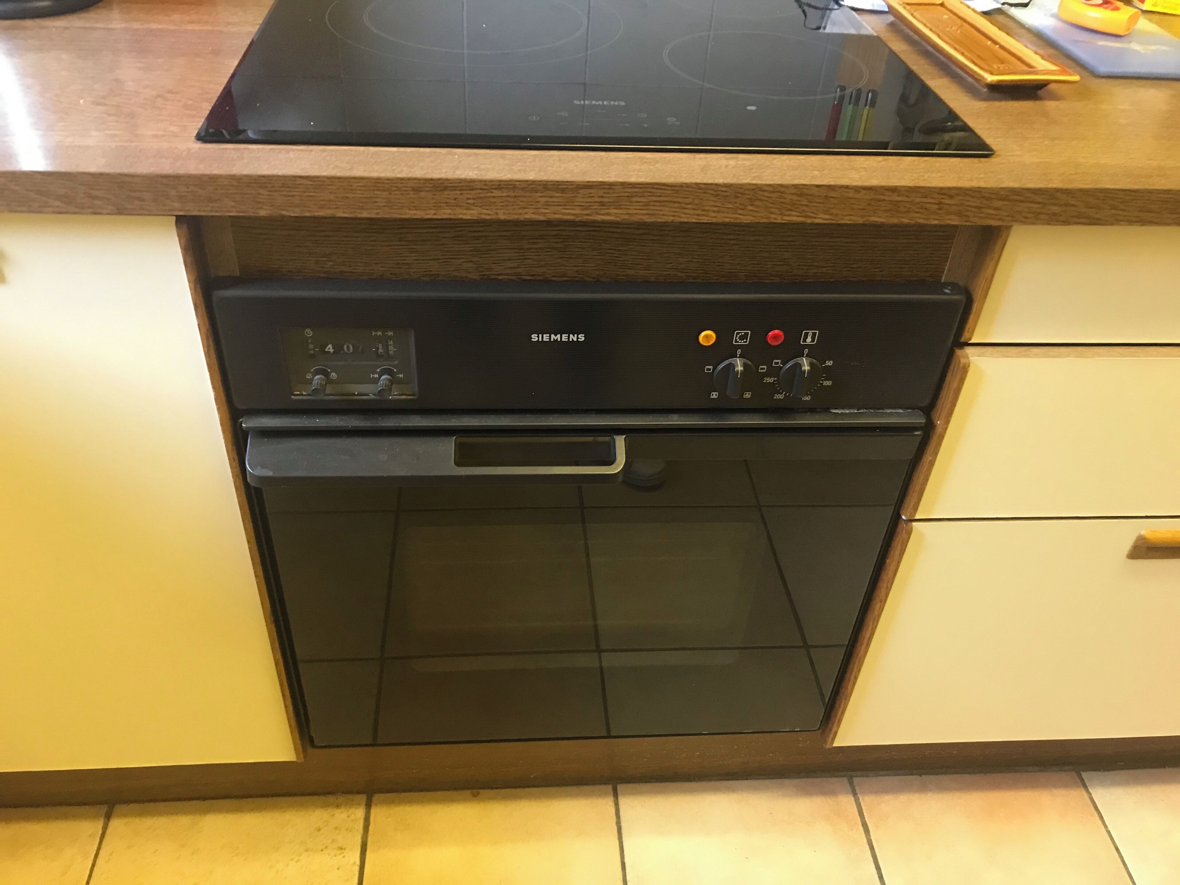 A kitchen with a built-in oven and a control panel.