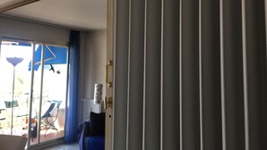 A room with a sliding glass door leading to an outdoor area with a table and chairs. - Seafront apartment close to beaches and Esterel: absolute calm (Saint-Raphaël)