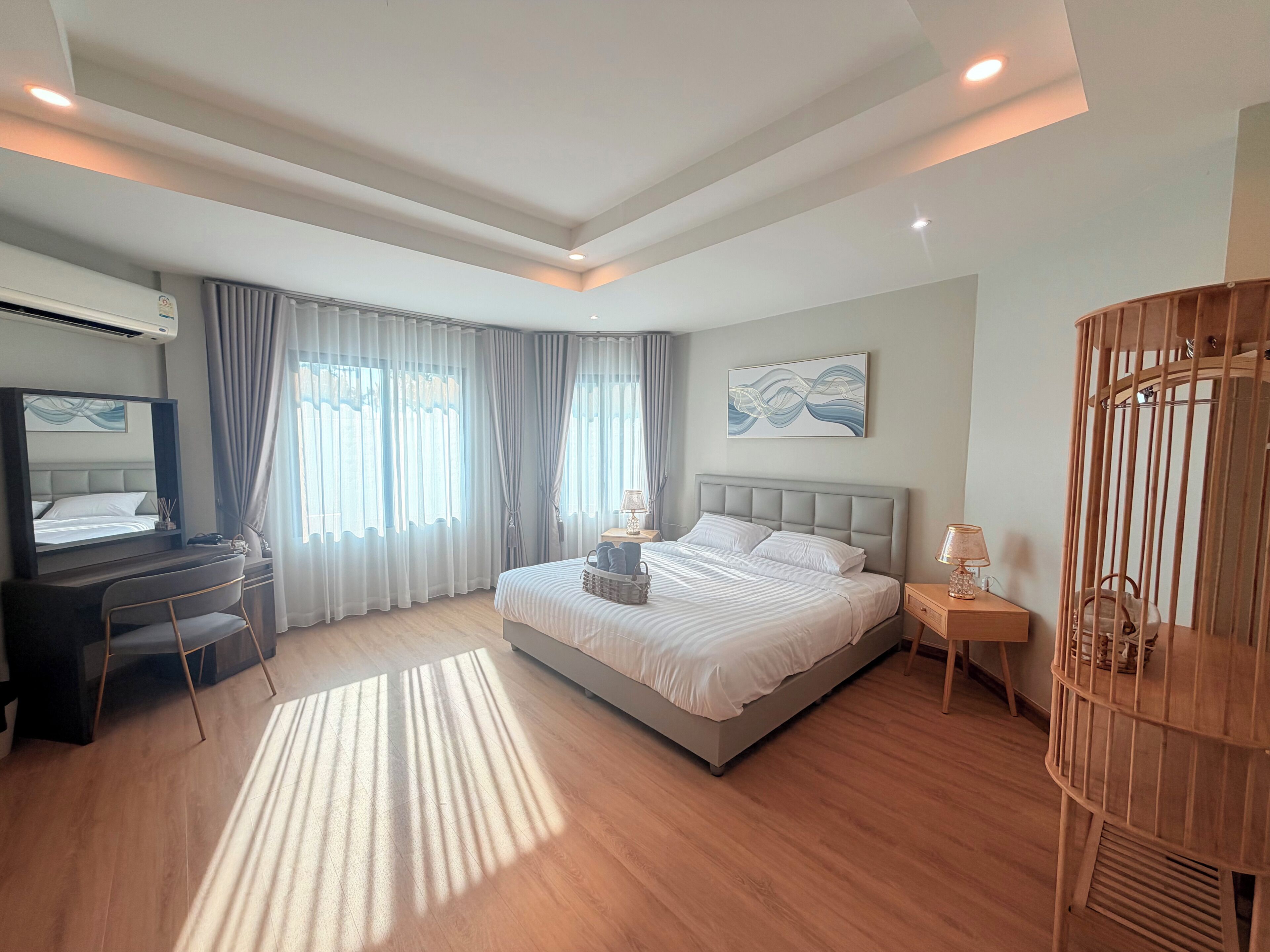 Un dormitorio moderno con cama, mesitas de noche, escritorio y silla.