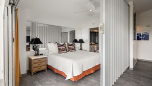 A bedroom with a bed, bedside tables, a mirror, and a wardrobe. - Ocean View 1-bed/2-bath Penthouse Suite at Waikiki Shore! (Honolulu)