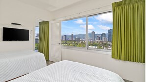 A hotel room with two beds, a TV, and a large window with a city view. - Ocean View Penthouse Suite, Steps to Beach, Sleeps 6! (Honolulu)