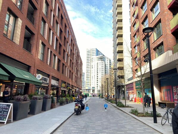 A street lined with brick buildings, some with balconies, and a clear sky.