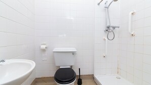 Een badkamer met toilet, wastafel en douche.