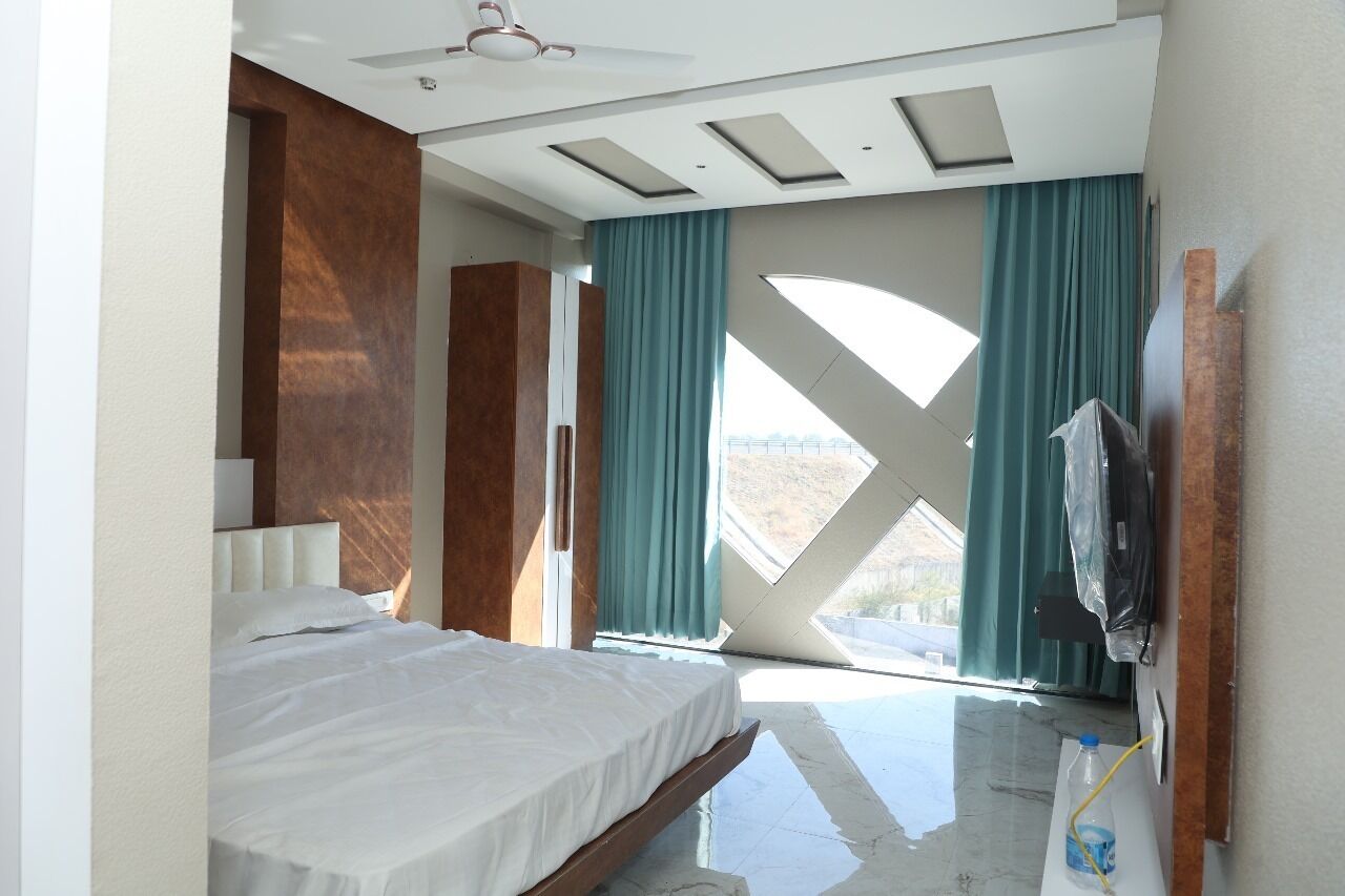 A modern hotel room with a large bed, a ceiling fan, and a view through a skylight.